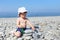 2 years toddler building pebbles tower on the beach