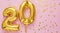 20 air balloon numbers on pink background. 20 k gold foil balloons with confetti. Birthday party flat lay with copy space long web