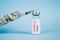 20 dollars bill and vial dose of COVID-19 vaccine with syringe against blue background with copy space - global vaccination and