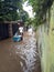 20 February 2021, a Man with Cart acrossing Flooding small street at Condet East Jakarta, Indonesia