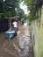 20 February 2021, a Man with Cart acrossing Flooding small street at Condet East Jakarta, Indonesia