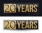 20 years anniversary gold banner on dark and white backgrounds.