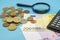 200 Euro banknote, coins, calculator and magnifier on a blue background. Finance concept.