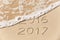 2016 2017 inscription written in the wet yellow beach sand being