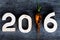 2016 on old grey wooden background with dirty fresh carrot inste