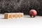 2016 sign on wooden cubes and red christmas ball lying on a snow