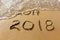 2017 and 2018 years written on sandy beach sea.