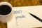 2017 list of goals on paper, a wooden table with a Cup of coffee