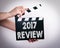 2017 review. Female hands holding movie clapper