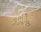 2018 and 2017 inscription written in the wet beach sand