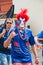 The 2018 FIFA World Cup. French fan with the face painted in the colors of the French tricolour shows the sign of the horns on Rev