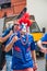 The 2018 FIFA World Cup. French fan with the face painted in the colors of the French tricolour shows the sign of the horns on Rev