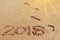 2018 inscription on the sand and footprints.