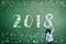 2018 new calendar year greeting by kid\\\'s hand drawing on school teacher\\\'s chalkboard with student\\\'s educational