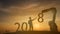 2018 silhouette engineering try to supervise the robot for complete 2018 new year with sunrise or sunset background