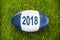 2018 written on a rugby ball in the grass