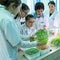 2019-09-01, Kazakhstan, Kostanay. Schoolgirls and a teacher in white coats in a biology or botany class are looking at sprouted