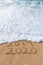 2019 2020 written in the sand with a wave erasing 2019