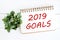 2019 goals on brown notebook paper at office desk background, ba