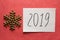 2019 Happy New Year card with text and golden glitter snowflake on pink background