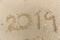 2019 text number handwriting on sand beach