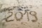 2019 written on the sea sand with foot prints.