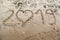 2019 written on the sea sand with heart shaped number 0