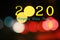 2020 Happy New Year. With colorful bokeh light on dark night background. Creative New Year design concept with number and text.