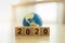 2020 New year , Global and Business concept. Close up of stack of wooden number block and mini world toy ball with copy space