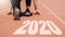 2020 Newyear , Athlete Woman starting on line for start running with number 2020 Start to new year