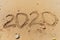 2020 number handwritten lettering on sand of sea beach