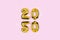 2020 numbers golden foil balloons mirror reflection on pink background. New year holiday party decoration. Metallic air balloons