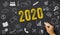 2020 written on a blackboard with icons