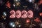 2020 year written with sparkle fireworks on night sky, surrounded by fireworks of different colors