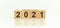 2021-2020 written on a wooden cube, white background