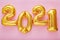2021 balloon text on pink background. Happy New year eve invitation with Christmas gold foil balloons 2021. Flat lay long web