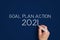 2021 goal plan action. man writes on a blue background 2021 goal plan action.