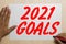 2021 goals typed on a book above a grunge wooden wall