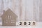 2021 Happy New Year with house model on table wooden background. Banking, real estate, investment, financial, savings and New Year
