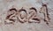 2021 inscription on the sand of the beach. Summer beach holidays in 2021. The message is handwritten