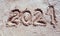 2021 inscription on the sand of the beach. Summer beach holidays in 2021. The message is handwritten