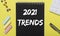 2021 trends inscription on black notebook and yellow background