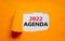 2022 agenda new year symbol. Words `2022 agenda` appearing behind torn orange paper. Beautiful orange background. Business, 2022