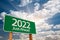 2022 Green Road Sign Over Dramatic Clouds and Sky