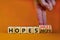 2022 hopes new year symbol. Businessman turns wooden cubes and changes words `Hopes 2021` to `Hopes 2022`. Beautiful orange