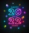 2022 neon light number happy new year and colorful bulb light at night design on block wall