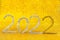 2022 numbers on a glowing background. Happy New Year greeting card and banner. Shiny golden Bokeh defocused texture