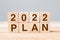 2022 PLAN cube block on table background. Resolution, GOAL, review, change, start and New Year holiday concepts