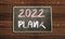 2022 plan written on chalkboard on wood table.