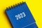 2023 blue desk calendar on yellow cover background.